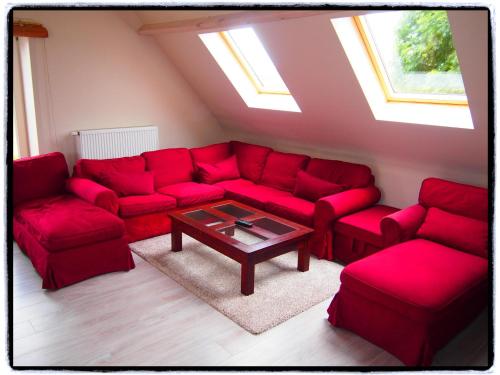 a living room with red couches and a coffee table at Comfy holiday home with terrace in Ellezelles in Ellezelles
