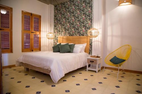 una camera da letto con un letto e una sedia di Hotel Boutique Casa Mia a Santa Marta