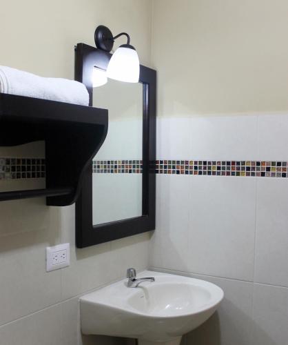 a bathroom with a sink and a mirror at Hostal de Asturias in San Salvador