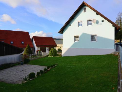 a white house with a green yard at Cosy holiday home in the Upper Palatinate Forest with a fenced garden and seating corner in Stadlern