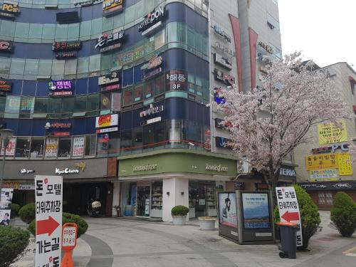 un edificio alto con señales delante en Hotel Don en Changwon