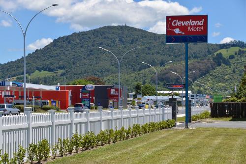 un cartello sul ciglio di una strada con una recinzione bianca di ASURE Cleveland Rotorua a Rotorua