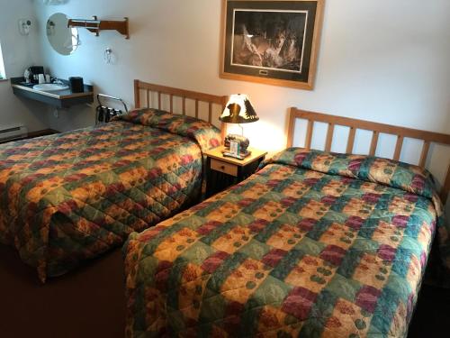a hotel room with two beds and a sink at Harborview Inn in Seward