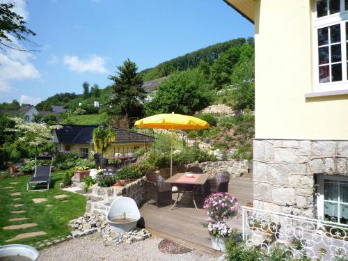 eine Terrasse mit einem Tisch und einem Sonnenschirm in der Unterkunft Quaint Apartment in Bad Pyrmont with Balcony near River in Bad Pyrmont