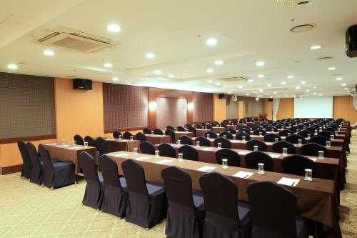 a conference room with long tables and chairs at Ocean Suites Jeju Hotel in Jeju