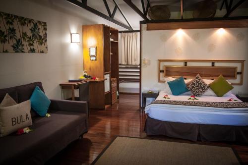a hotel room with a bed and a couch at First Landing Beach Resort & Villas in Lautoka