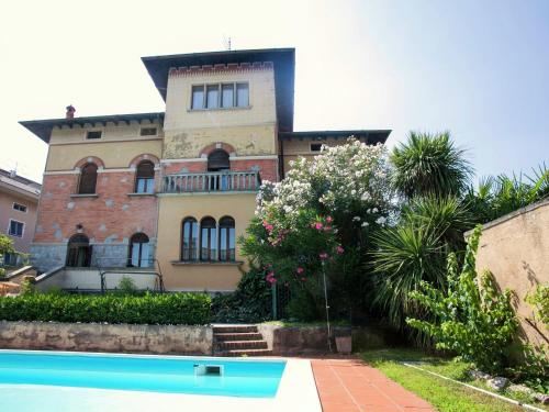 a house with a swimming pool in front of it at Belvilla by OYO Villa Melina in Desenzano del Garda