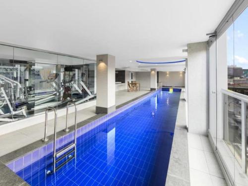 a large swimming pool with blue tiles in a building at 96 North Terrace Embassy in Adelaide