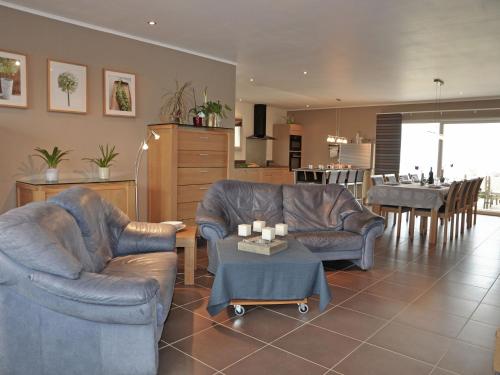 ein Wohnzimmer mit 2 Ledersesseln und einem Tisch in der Unterkunft Luxury villa with pool in Thermes Magnoac in Thermes-Magnoac