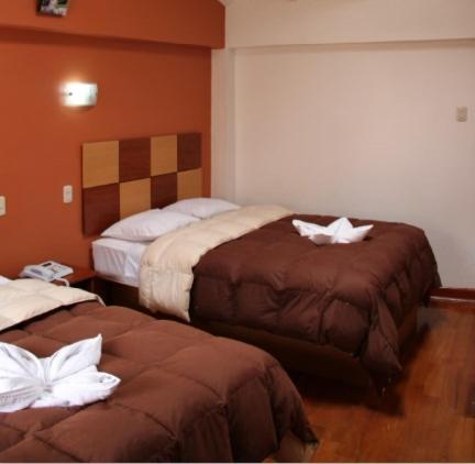 Habitación de hotel con 2 camas y toallas blancas. en Tierra del Inka, en Cusco
