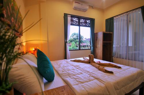 een slaapkamer met een bed met een teddybeer erop bij Pondok Muwa Guest House in Ubud