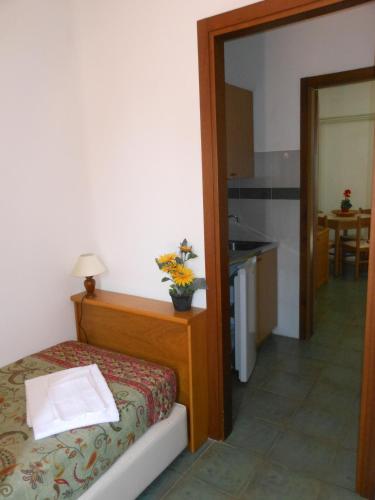 a small bedroom with a bed and a kitchen at Il Lido in Giannella