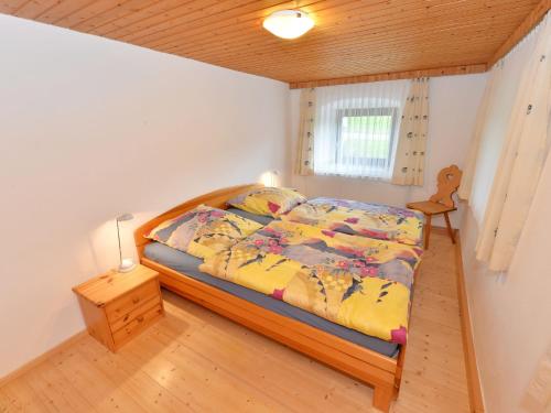 a bedroom with a bed with a wooden bed frame at Holiday home with terrace in Weigelsberg