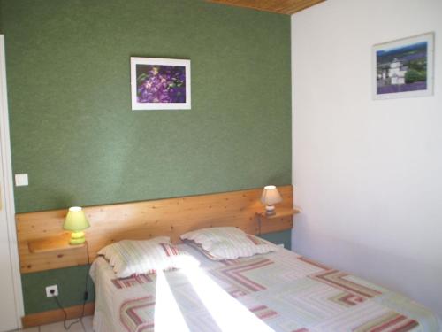 a bedroom with a bed and a green wall at Family Escape in Les Salelles in Chambonas