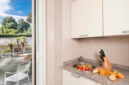 a kitchen counter with a sink with fruits and vegetables at Residence Carl&Do in Baveno