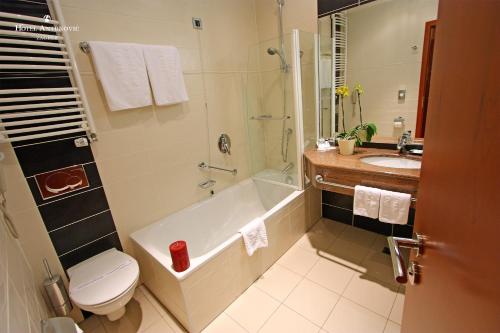 a bathroom with a tub and a toilet and a sink at Hotel Antunovic Zagreb in Zagreb