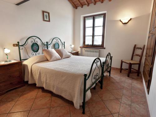 フォイアーノ・デッラ・キアーナにあるGraceful Home in Foiano della Chiana with Gardenのベッドルーム1室(ベッド1台、椅子、窓付)