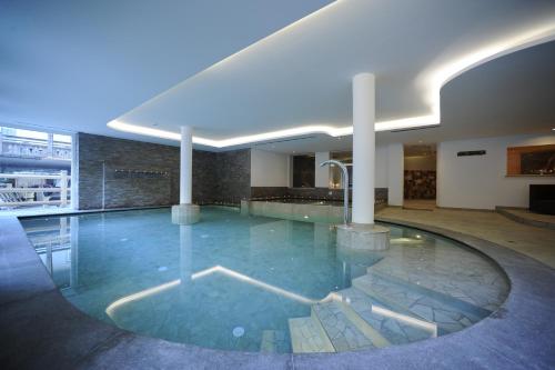 a swimming pool in a building with a pool at Alpstyle Hotel Albolina Wellness & Beauty in Canazei