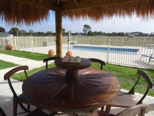 a wooden table and chairs in front of a pool at The Oxley Estate in Portarlington