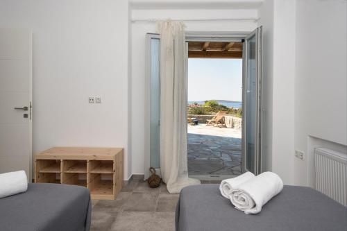a bedroom with two beds and a door to a patio at Villa Theros in Aliki