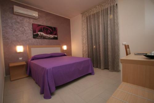 カステッルッツォにあるB&B Coppolaのベッドルーム(紫色のベッド1台、窓付)