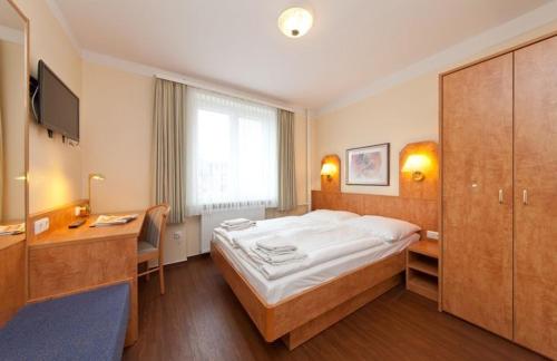 Hotel Wikinger Hof tesisinde bir odada yatak veya yataklar