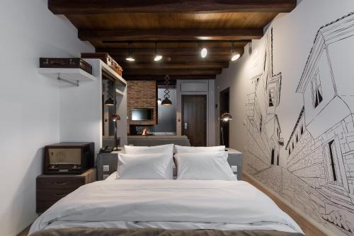 Olganos VL Luxury Rooms & Suites في فيريا: غرفة نوم مع سرير مع رسم على الحائط