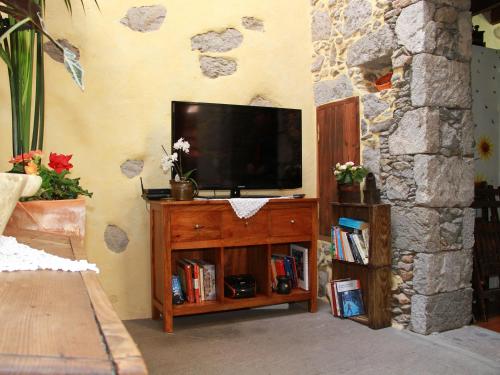 una sala de estar con TV en un centro de entretenimiento de madera en Casa Emblemática La Pileta - Doramas, en Agüimes