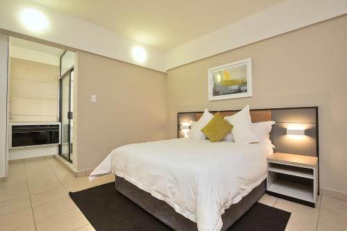a bedroom with a large bed with white sheets and pillows at The Park Lodge Hotel in Pretoria