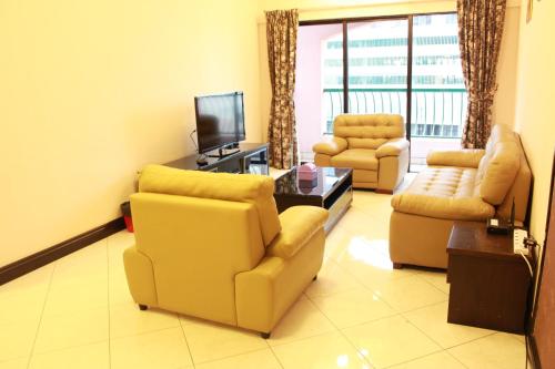 a living room with two chairs and a television at Town Condo - Marina Court Kota Kinabalu in Kota Kinabalu
