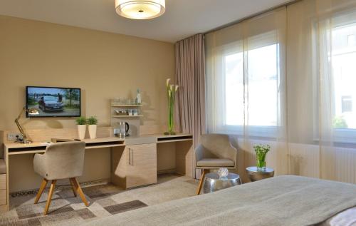 a bedroom with a desk with two chairs and a bed at Hotel Residenz Oberhausen in Oberhausen