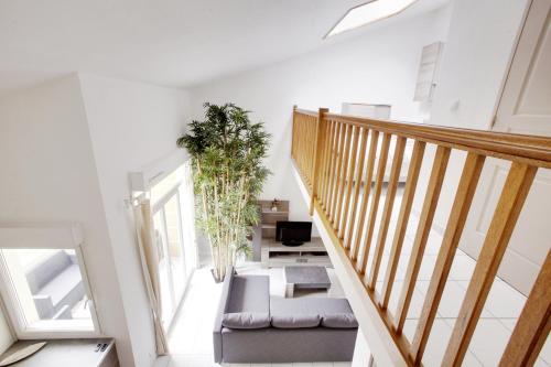 um quarto com uma escada com um sofá e uma cadeira em Welkeys Apartment Lattes em Lattes