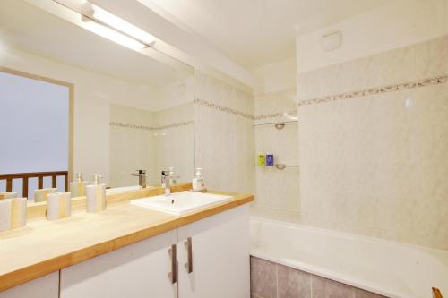 uma casa de banho com um lavatório e um espelho em Welkeys Apartment Lattes em Lattes