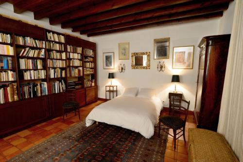 um quarto com uma cama branca e estantes em L'Atelier du Grison em Callen