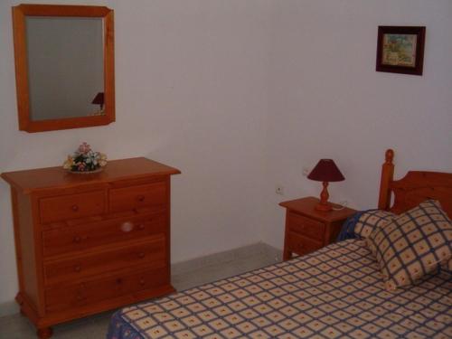 a bedroom with two beds and a dresser and a mirror at Urbanización Naturista Bahía de Vera in Vera