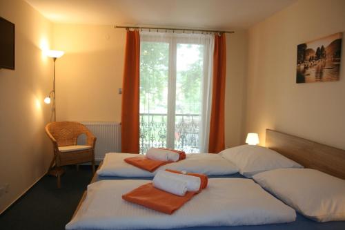a bedroom with two beds with towels on them at Hotel Praha Potštejn in Potštejn