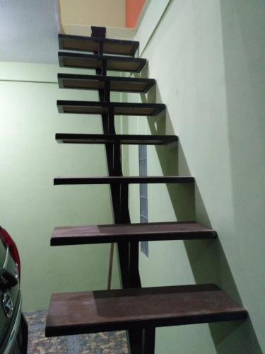 un conjunto de escaleras en una casa con escalones de madera en mas Eko Jlatren kost homestay en Prambanan