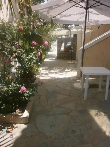 a patio with a white table and some flowers at Anastasia Apartments in Korissia