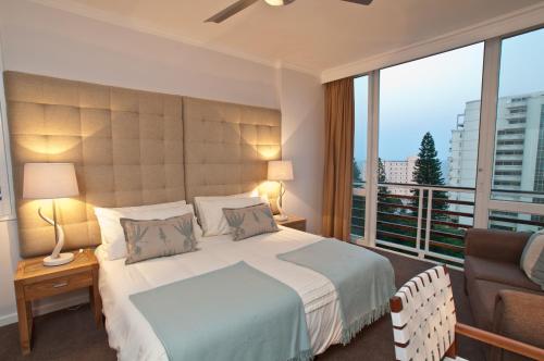 um quarto com uma cama grande e uma varanda em 506 Lighthouse Mall - by Stay in Umhlanga em Durban