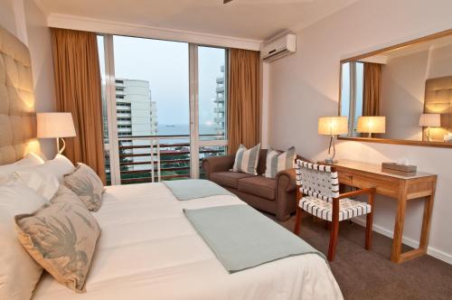 a hotel room with a bed and a desk and a window at 506 Lighthouse Mall - by Stay in Umhlanga in Durban