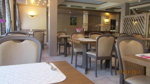 jadalnia ze stołami i krzesłami w restauracji w obiekcie Hotel Tannenhof w mieście Lauterbach