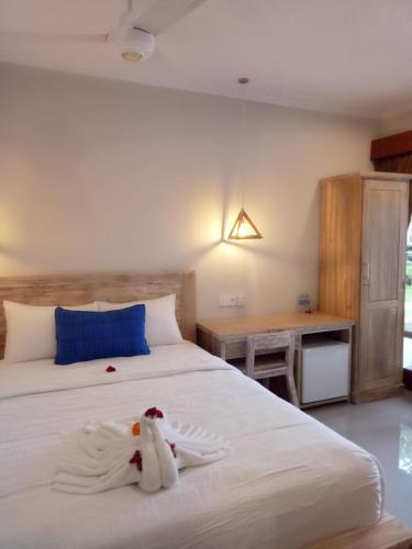 a bedroom with a bed with towels on it at Wisna House in Sanur
