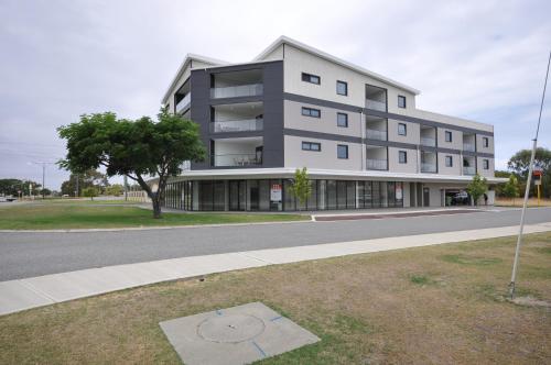 a large building on the side of a street at Coastal By Rockingham Apartments in Rockingham