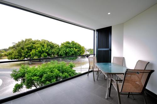a dining room with a table and a large window at Coastal By Rockingham Apartments in Rockingham
