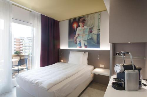 a bedroom with a white bed and a painting on the wall at Hotel City Locarno in Locarno