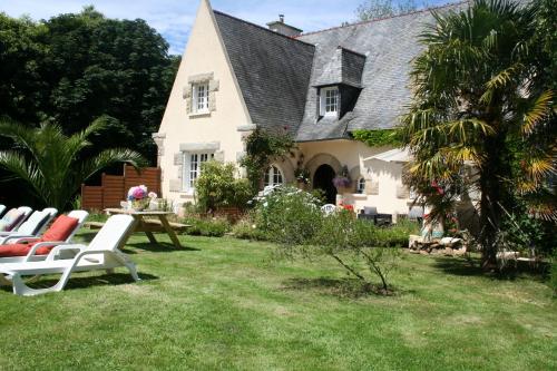 a house with chairs and a table in the yard at Chez Renée et Raynal B&B in Plounévez-Lochrist