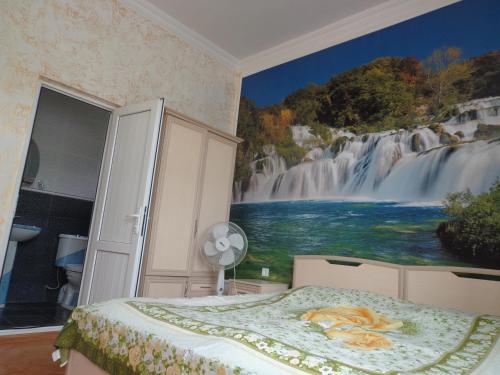 sypialnia z malowidłem wodospadowym na ścianie w obiekcie Guest House in Sarpi w mieście Batumi