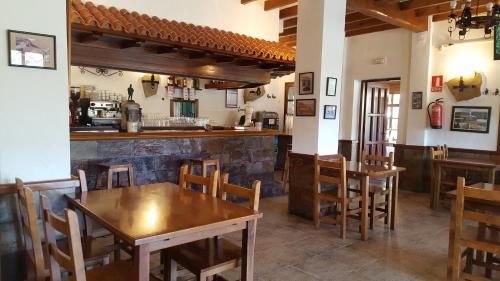 a restaurant with wooden tables and chairs and a bar at Hotel Valle Las Luiñas in Soto de Luiña