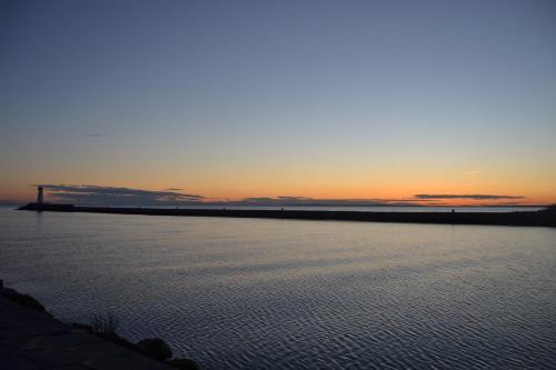 a large body of water with a sunset in the background at Villa L'Amiraute in Agde