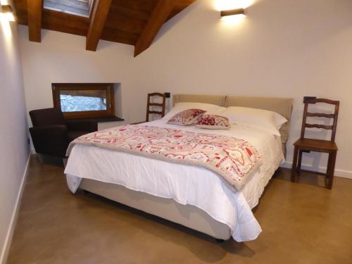 1 dormitorio con 1 cama grande y 1 silla en Malherbes en Aosta